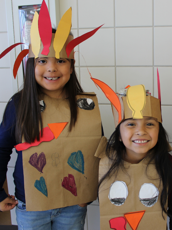 Students smile and wear turkey costumes